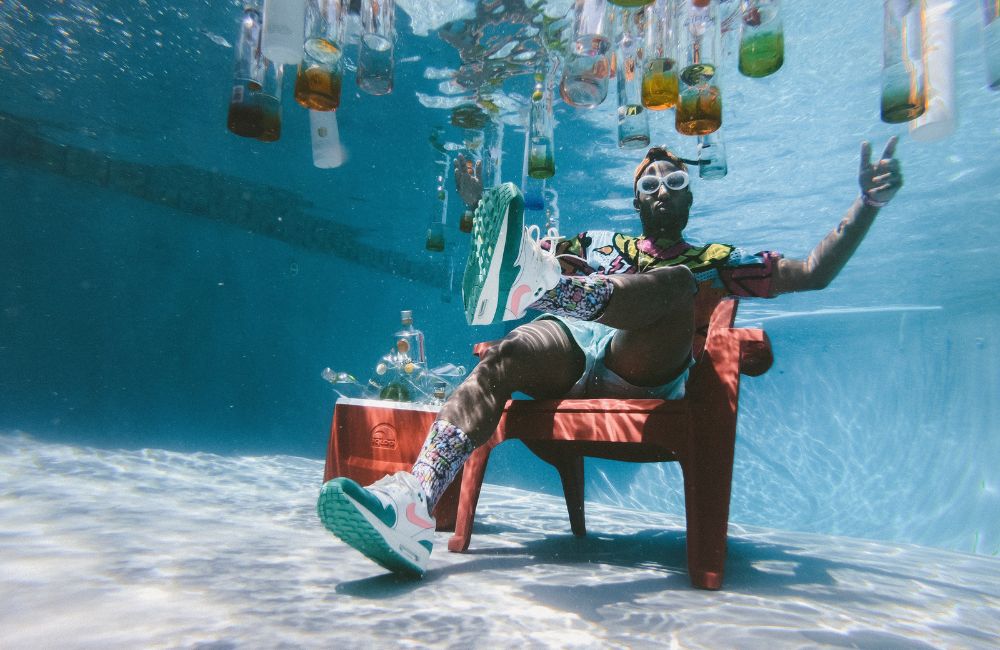 Hombre tomando café en verano dentro de la piscina