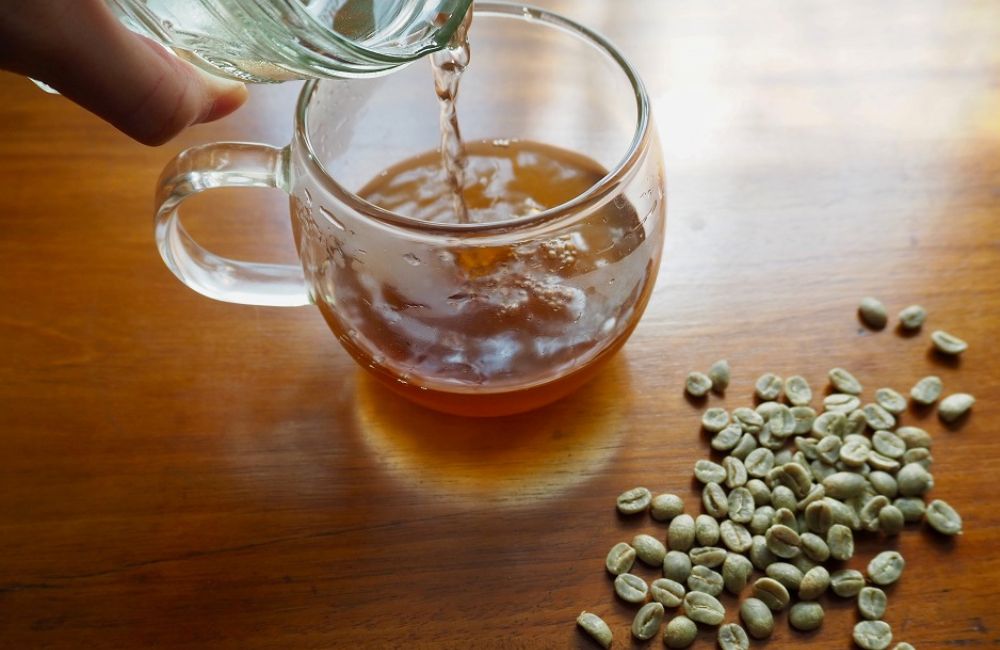Manos sirviendo preparación de café verde en infusión